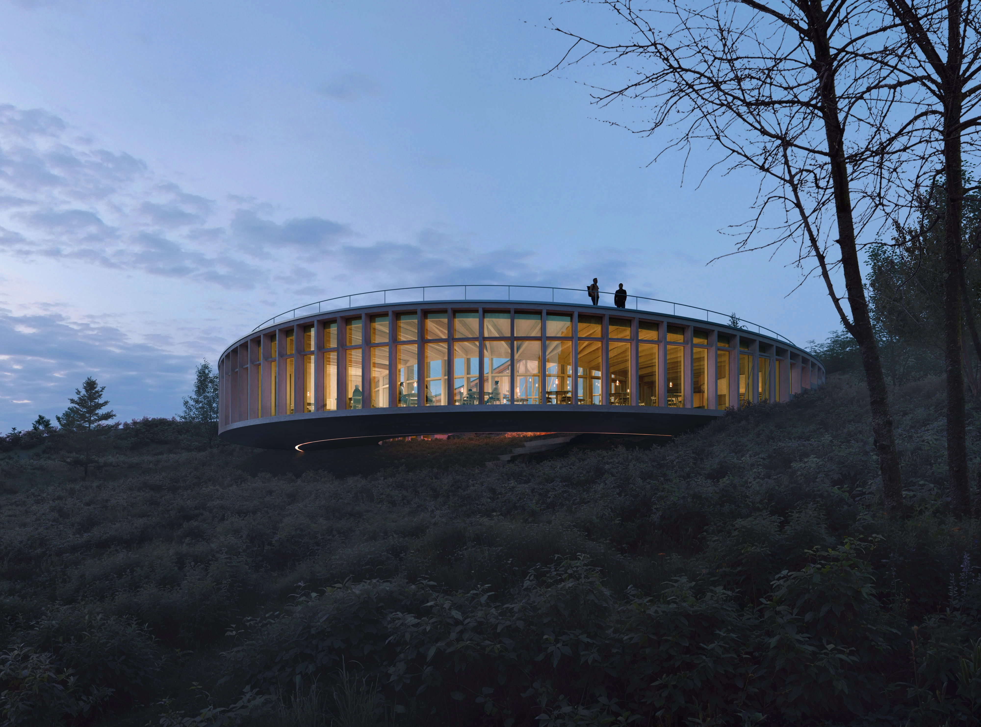 Circular glass building glowing at dusk in the Preikestolen landscape.