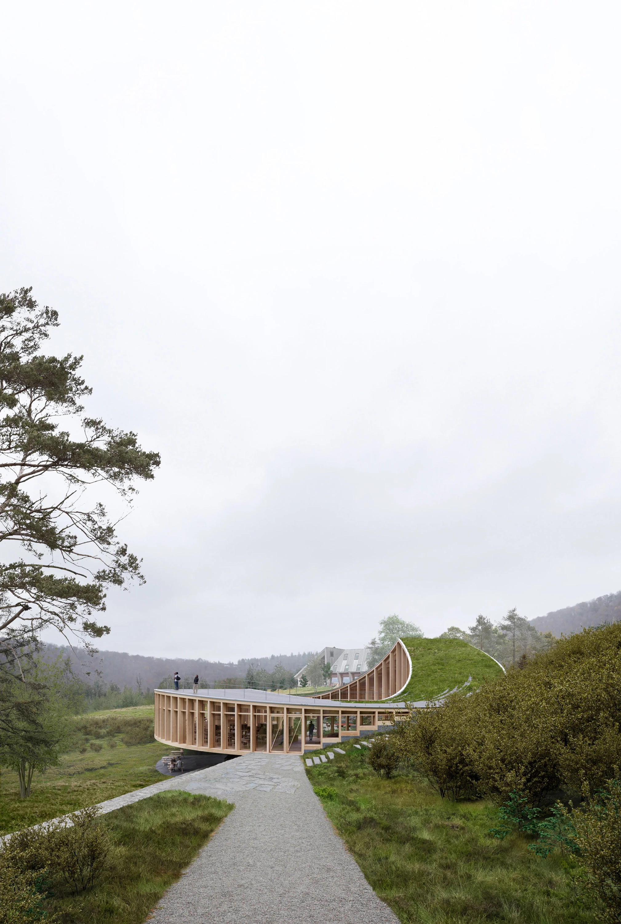 The circular green-roofed Nest visitor centre in mist at Preikestolen, with a path to the entrance and people on the roof terrace.