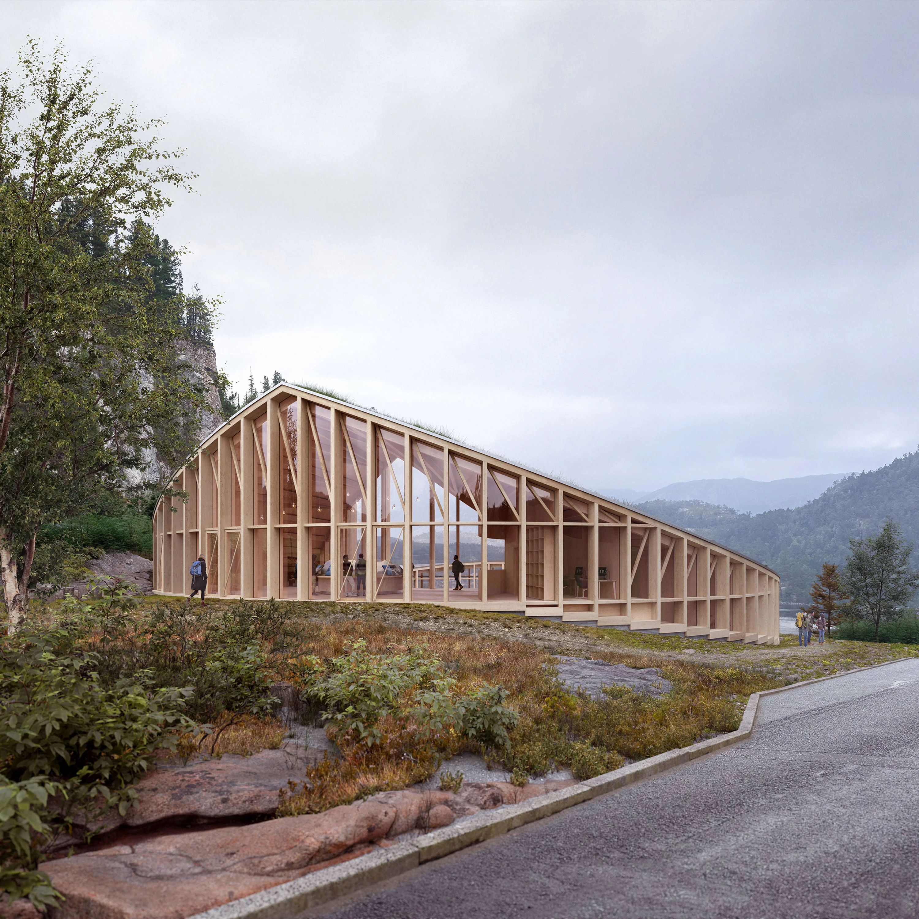 Hikers with backpacks passing the Nest visitor centre, its green roof set against the fjord beyond.